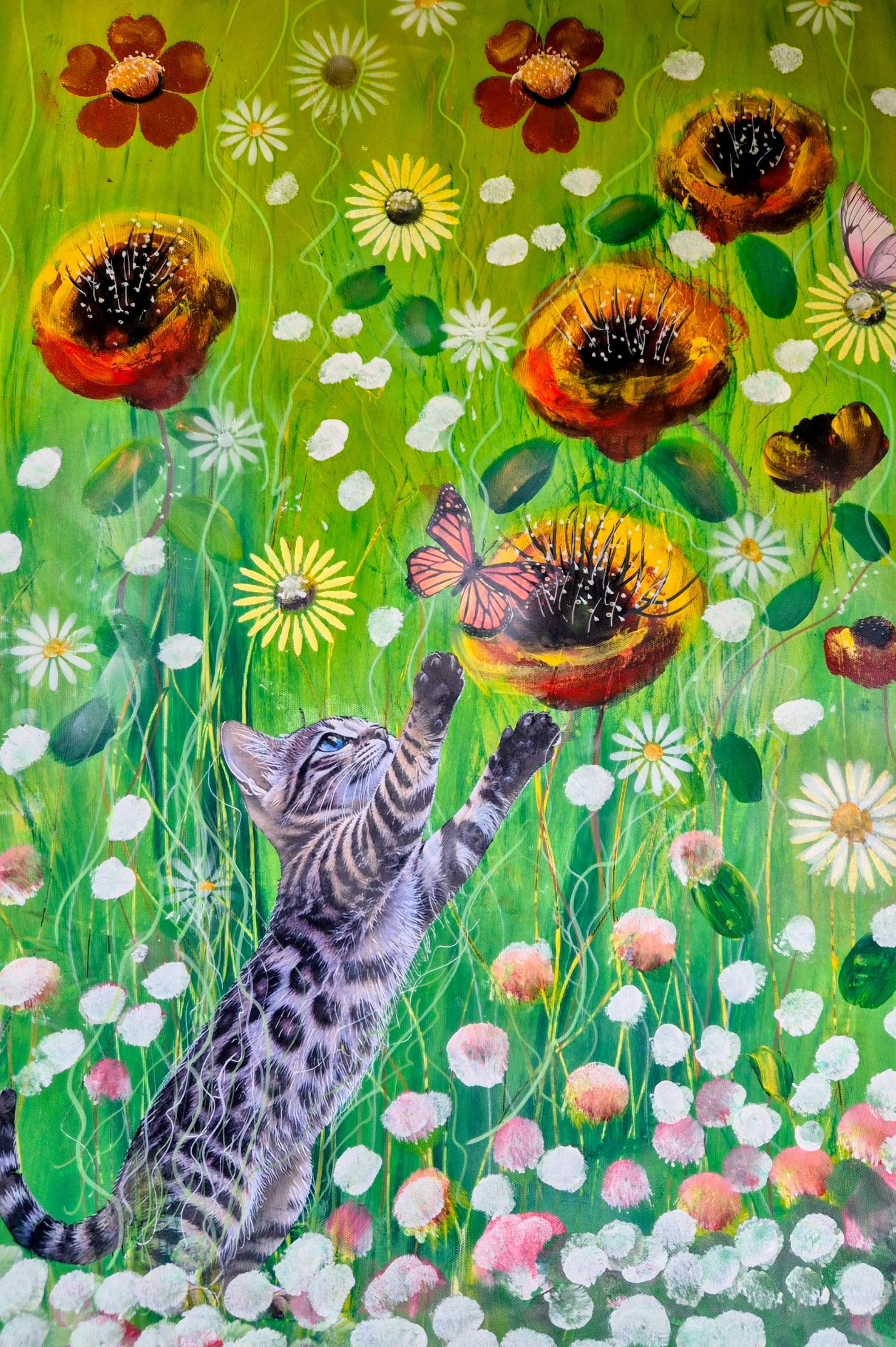 Bengal kitten reaches up toward catch a Butterfly in a wild flower garden